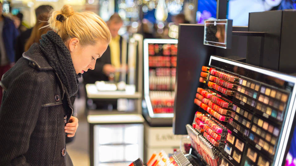 女性顾客在零售健康美容店观看化妆品展示